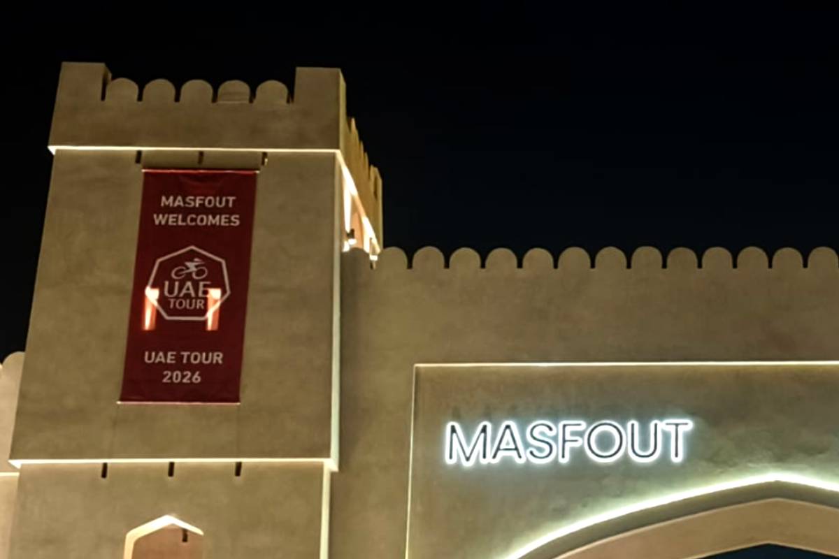 Close-up of the Masfout gate facade mesh banner for UAE Tour 2026, shown beside the illuminated “Masfout” sign at night.