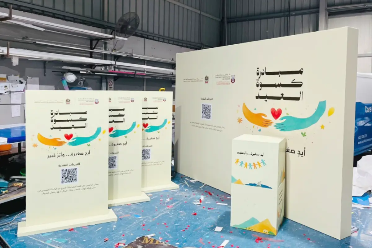 Custom event counter with branded backdrop wall and freestanding display panels produced in Abu Dhabi