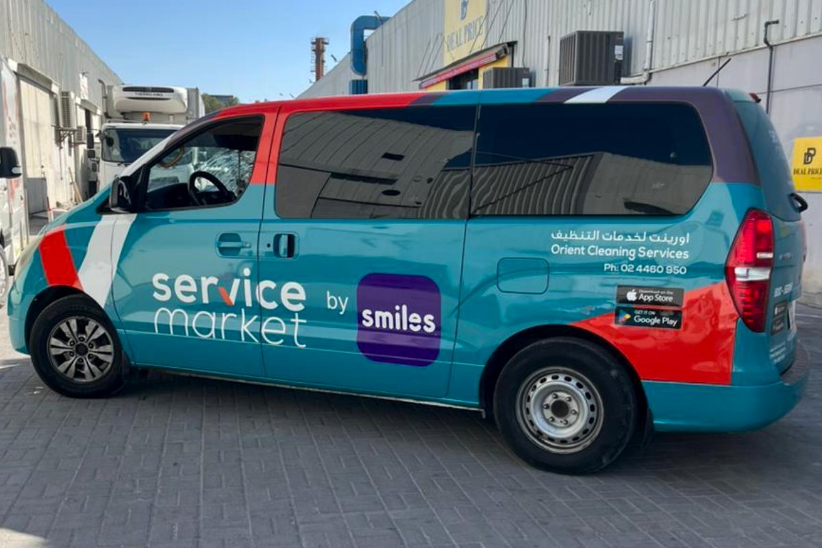 Service Market full vehicle wrap with seamless teal and red graphics in Abu Dhabi
