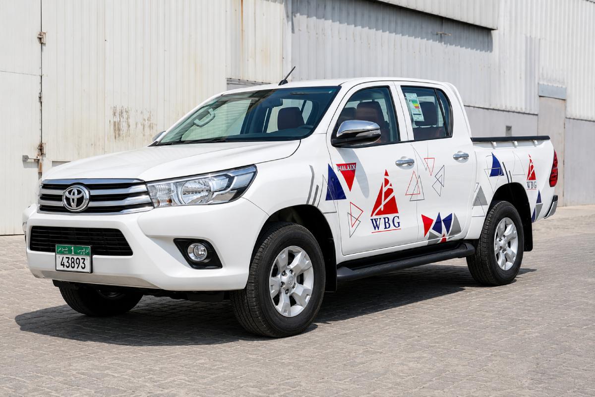 Partial branding on a white Toyota Hilux pickup in Abu Dhabi
