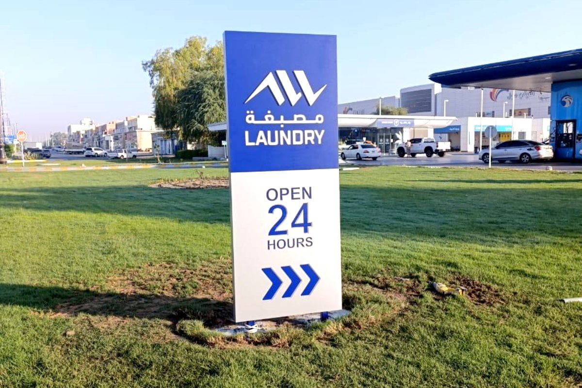 Pylon sign for Al Waqaed Laundry at an ADNOC station, Abu Dhabi