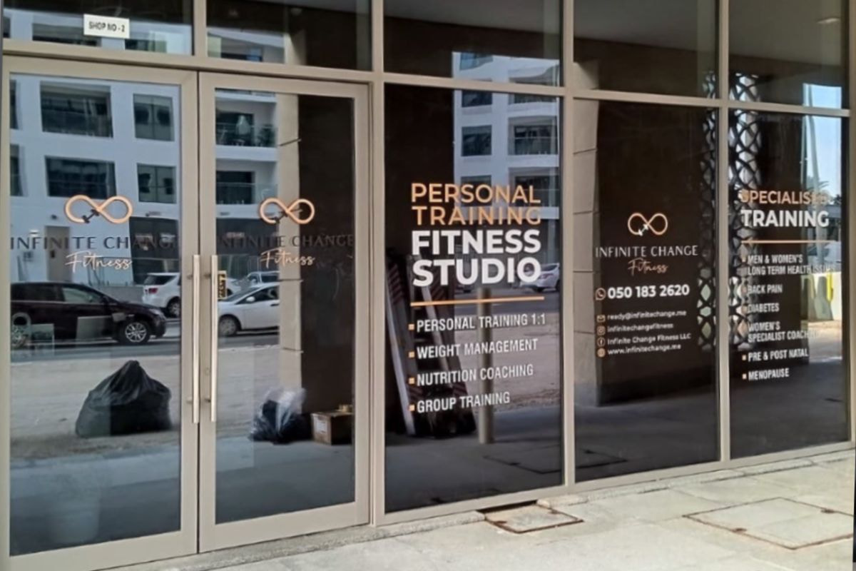 Cut vinyl opening-hours lettering on a storefront entrance door